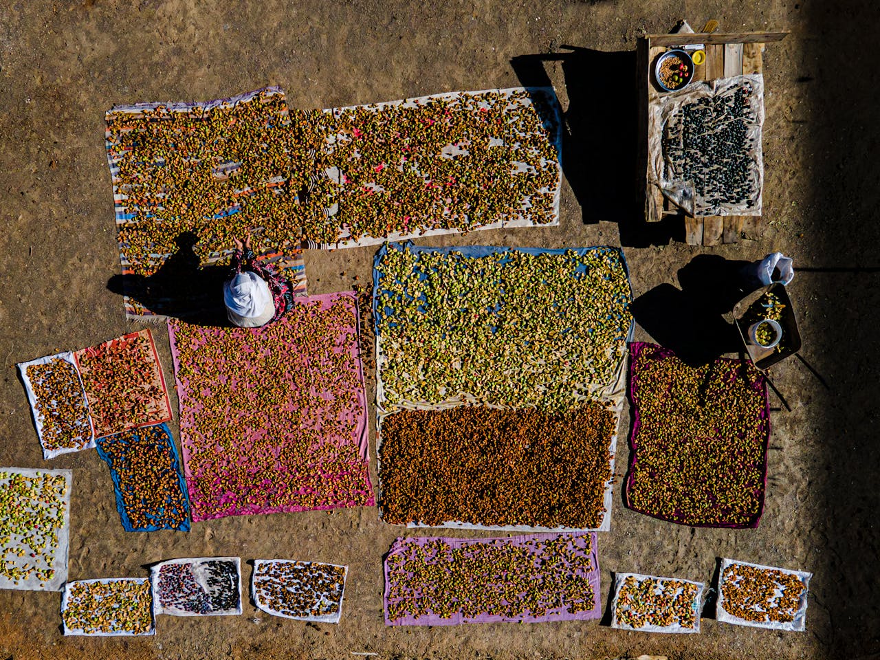 Brightly colored fruits drying on cloths under sunlight in Bitlis, Türkiye.